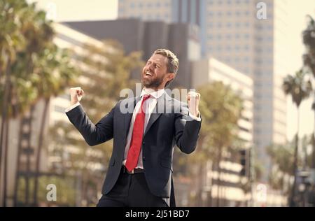 uomo d'affari felice in vestito e cravatta rossa che celebra il successo di affari esprime felicità, eccitazione Foto Stock