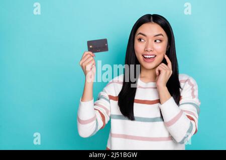 Foto di carina adorabile signora felice di avere carta di credito utilizzando l'opzione cashback isolato su sfondo color turchese Foto Stock