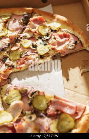 Deliziose fette di pizza in scatola di cartone sul tavolo Foto Stock