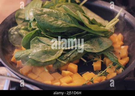 Spinaci in un wok con altre verdure Foto Stock