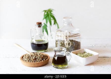 Prodotti di canapa: Olio, tè, semi sgusciati e interi, yogurt con semi, pianta di cannabis Foto Stock