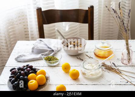 Colazione a base di granola, miele, yogurt e frutta Foto Stock