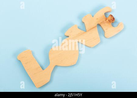 Parola Amore fatto in legno; Foto su sfondo blu Foto Stock