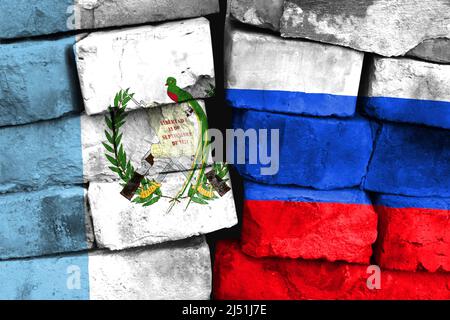 Concetto del rapporto tra Guatemala e Russia con due bandiere dipinte su un muro di mattoni danneggiato Foto Stock