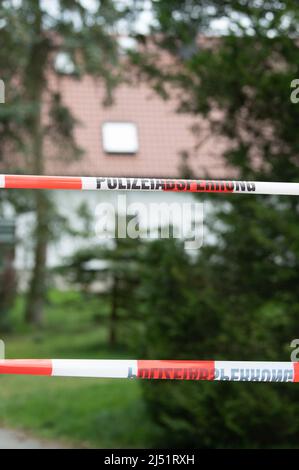 Chemnitz, Germania. 19th Apr 2022. Un nastro barriera è appeso su un vialetto di fronte ad una casa residenziale. Quattro morti sono stati trovati nella casa nel distretto di Mittelbach fine Lunedi sera. Credit: Sebastian Kahnert/dpa/Alamy Live News Foto Stock