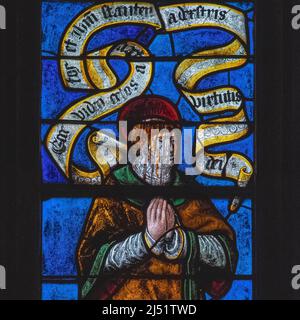 Stoico nella morte: Il sangue fluisce lungo il volto del primo martire del cristianesimo, Santo Stefano, mentre si inginocchia in preghiera in attesa di morire sotto uno sbarramento di rocce e pietre: Dettaglio quadrato del pannello centrale in finestra dei primi 1500s vetrate colorate nella Église Saint-Rémi a Ceffonds, nella regione Champagne della Francia nord-orientale. La finestra raffigura anche i due esecutori di Stephen. Foto Stock