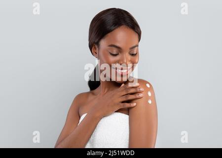 Donna in asciugamano grigio nella doccia con una spazzola per massaggio in  legno per pulire la pelle Foto stock - Alamy