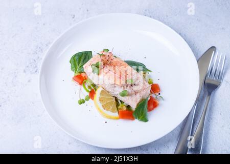 Trota (salmone) con verdure, limone e micrograni, cotti con il metodo confit. Piatto francese tradizionale. Passo dopo passo. Primo piano. Foto Stock