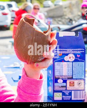 Mano che tiene latte cioccolato uovo di Pasqua Foto Stock