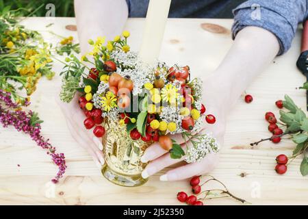 Fiorista al lavoro: Come fare il portacandele autunno decorato con rosa, frutti di biancospino e tansy. Passo dopo passo, tutorial. Foto Stock