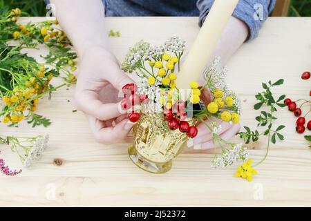 Fiorista al lavoro: Come fare il portacandele autunno decorato con rosa, frutti di biancospino e tansy. Passo dopo passo, tutorial. Foto Stock