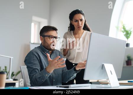 Stress sul luogo di lavoro. Il boss femminile arrabbiato spolding ha sottolineato dipendente maschile per aver commesso un errore nel progetto di business in ufficio Foto Stock