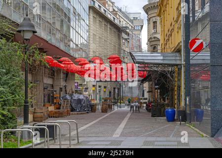 Belgrado, Serbia - 09 aprile 2022: Strada piccola con ombrelloni rossi decor nel centro della capitale in Primavera. Foto Stock