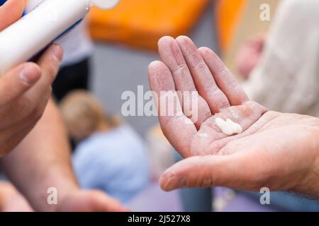 La mano dell'uomo del primo piano applica il magnesio sulla sua mano prima dell'addestramento nella palestra. Foto Stock
