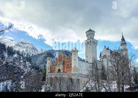 Castello di Neuschwanstein in un bel paesaggio invernale ghiacciato con nuvole e sole Foto Stock