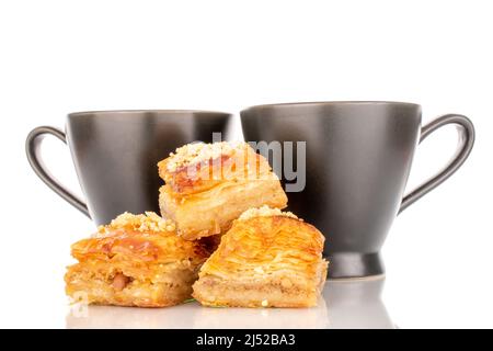 Dolce baklava classico con piatti in ceramica, macro, isolato su sfondo bianco. Foto Stock