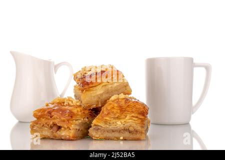 Dolce baklava classico con piatti in ceramica, macro, isolato su sfondo bianco. Foto Stock