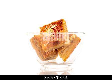 Dolce baklava classico con vetreria, macro, isolato su sfondo bianco. Foto Stock