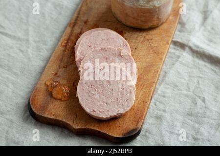 Jagdwurst fatto in casa su un rustico asse di legno, vista laterale. Foto Stock