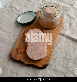 Jagdwurst fatto in casa su un rustico asse di legno, vista ad angolo basso. Foto Stock