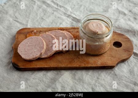 Jagdwurst fatto in casa su un rustico asse di legno, vista ad angolo basso. Foto Stock