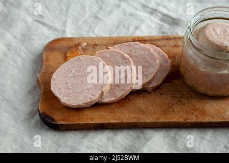 Jagdwurst fatto in casa su un rustico asse di legno, vista laterale. Primo piano. Foto Stock