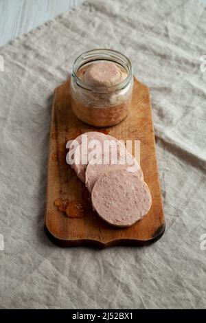 Jagdwurst fatto in casa su un rustico asse di legno, vista laterale. Foto Stock