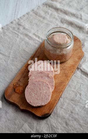 Jagdwurst fatto in casa su un rustico asse di legno, vista laterale. Foto Stock