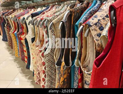 Abbigliamento indiano uomo ultima moda appeso su appendiabiti, in mostra nel negozio al dettaglio nel mercato, abbigliamento da matrimonio per gli uomini India Foto Stock