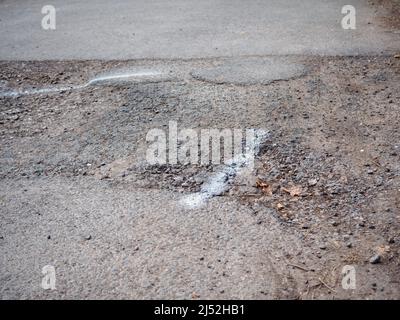 Pothole sulla strada britannica, problema importante per danni all'automobile, incidenti e reclami assicurativi Foto Stock