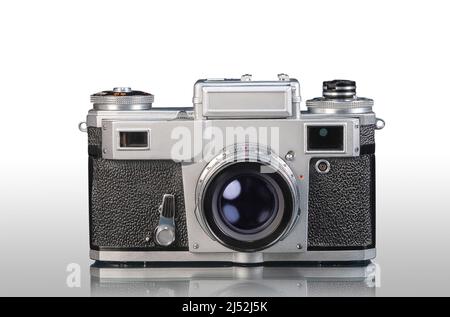 vecchia fotocamera compatta analogica su sfondo bianco con riflessi Foto Stock