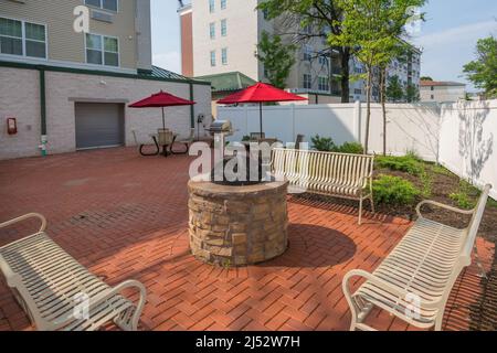 Panchine e fossa di fuoco in appartamento area comune al di fuori del patio Foto Stock