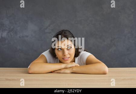 La giovane donna guarda in su pensando alle opportunità Foto Stock