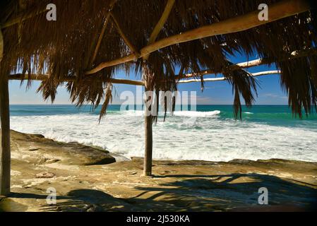 Punto di riferimento storico Windansea Surf Shack adiacente alle onde e surf lungo la spiaggia in una luminosa giornata di sole a Windansea Beach, la Jolla, California, USA Foto Stock