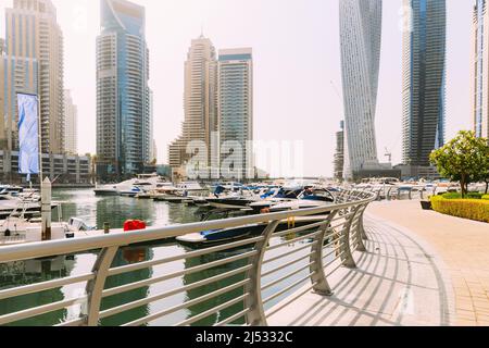 Gli yacht sono ormeggiati al molo della città, nel molo di Dubai Marina, nella soleggiata giornata estiva. Skyline urbano. Sfondo urbano Foto Stock