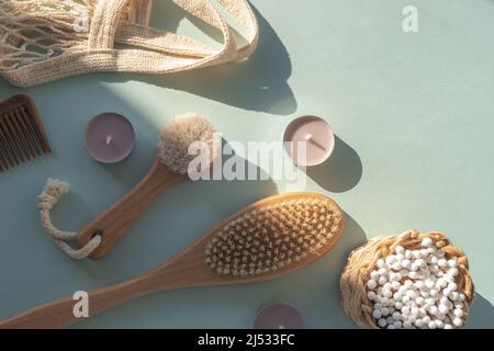 Cosmetici naturali, spazzole in legno, bastoncini per la pulizia delle orecchie, pettine e borsa a rete su tavolo blu chiaro. Bellezza, spa e benessere. Concetto di zero rifiuti. Vista dall'alto Foto Stock