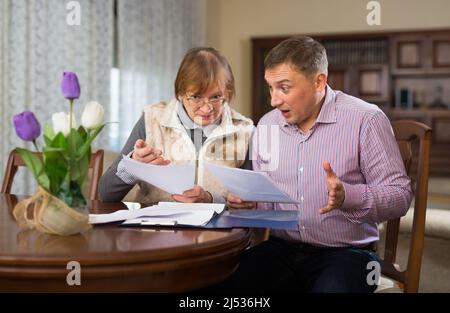 Donna con figlio che compila i documenti Foto Stock
