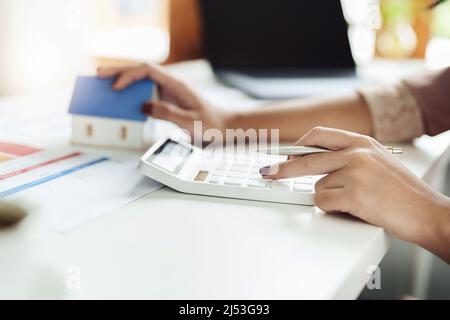 Agenti immobiliari, acquisti e vendite di terreni, tasse di proprietà, proprietari di immobili stanno usando calcolatrici per calcolare le spese di casa e di tasse di terra a. Foto Stock