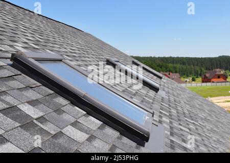 Lucernario attico. Asfalto Shingles House Roofing costruzione con finestre Attico tetto, lucernari impermeabilizzanti. Lucernari. Foto Stock