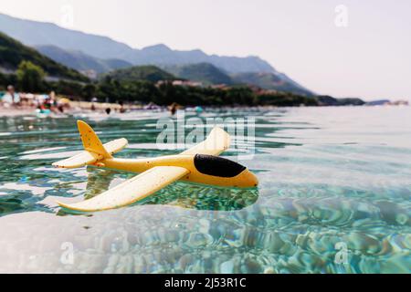 Piano giocattolo giallo giacente sull'acqua Foto Stock