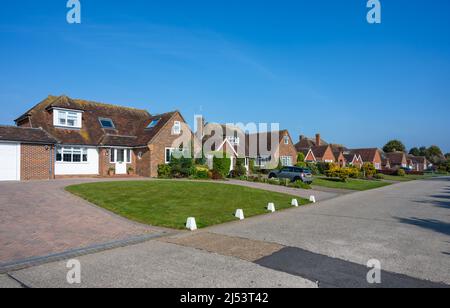 Fila di case indipendenti su una strada privata senza marciapiedi in Willowhayne Private Estate, East Preston, West Sussex, Inghilterra, Regno Unito. Foto Stock