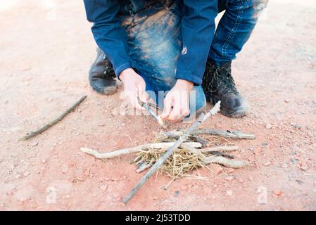 Iniziare un fuoco con un firesteel, attrezzatura di sopravvivenza e avventura, abilità all'aria aperta, uomo che fa un falò Foto Stock