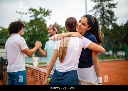 Gruppo di giocatori di tennis che danno una stretta di mano dopo una partita Foto Stock