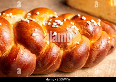 Bel pane dorato cotto a tre treccia con uova lavate e zucchero di grandine. Challah è un pane speciale di origine ebraica Ashkenazi, solitamente intrecciato e typi Foto Stock