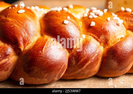 Bel pane dorato cotto a tre treccia con uova lavate e zucchero di grandine. Challah è un pane speciale di origine ebraica Ashkenazi, solitamente intrecciato e typi Foto Stock