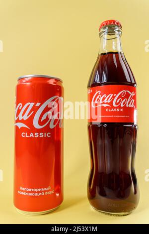 Tyumen, Russia-03 aprile 2022: Prodotti della Coca Cola Company, multinazionale americana delle bevande. Sfondo giallo. Foto verticale Foto Stock