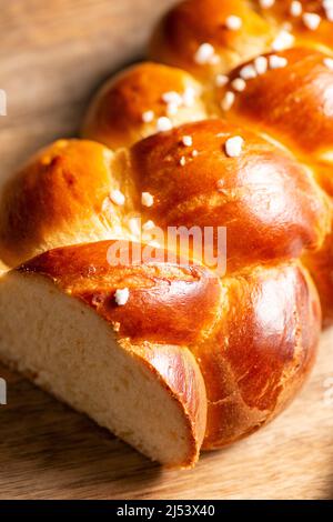 Bel pane dorato cotto a tre treccia con uova lavate e zucchero di grandine. Challah è un pane speciale di origine ebraica Ashkenazi, solitamente intrecciato e typi Foto Stock