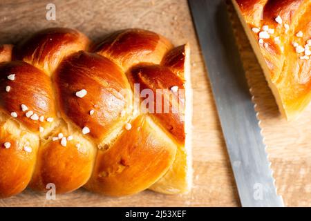 Bel pane dorato cotto a tre treccia con uova lavate e zucchero di grandine. Challah è un pane speciale di origine ebraica Ashkenazi, solitamente intrecciato e typi Foto Stock