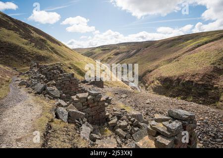 I resti derelitti della vecchia industria mineraria del piombo in Gunnerside Gill, Swaledale, Yorkshire del Nord, Inghilterra, Regno Unito Foto Stock