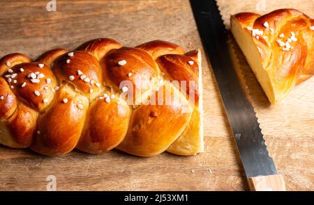 Bel pane dorato cotto a tre treccia con uova lavate e zucchero di grandine. Challah è un pane speciale di origine ebraica Ashkenazi, solitamente intrecciato e typi Foto Stock